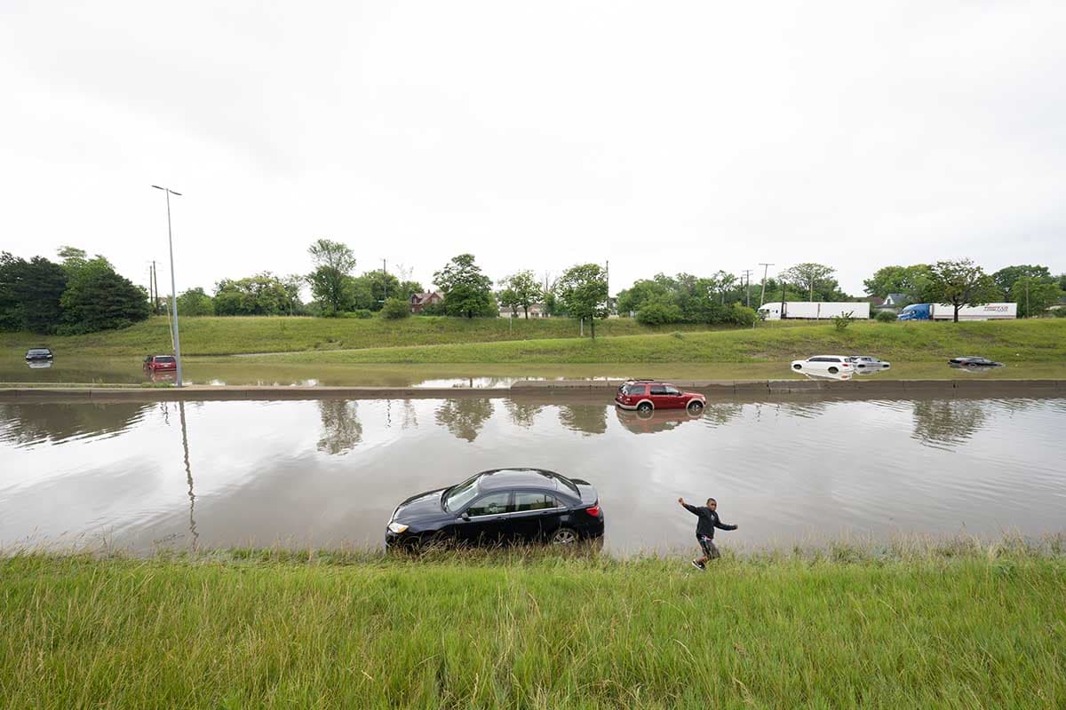 MAIN-StephenMcGee-boy-plays-near-car-on-flooded-freeway